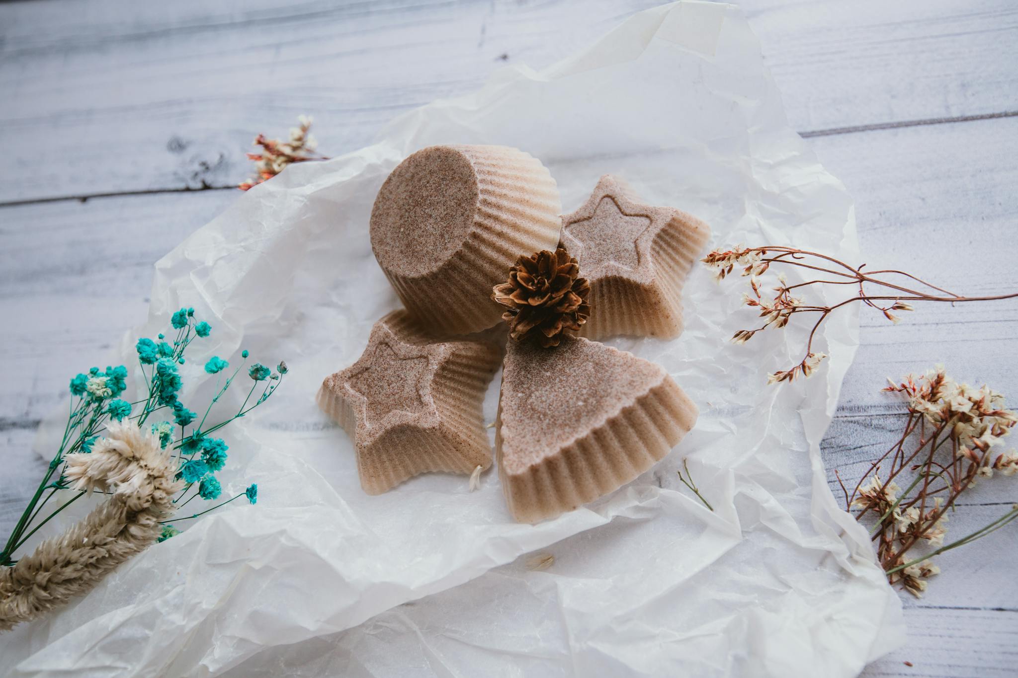 Handmade Christmas soaps arranged on paper with gentle dry flowers